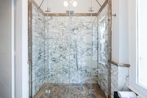 a shower with a glass door in a bathroom at Glimpse Hotel in Florence