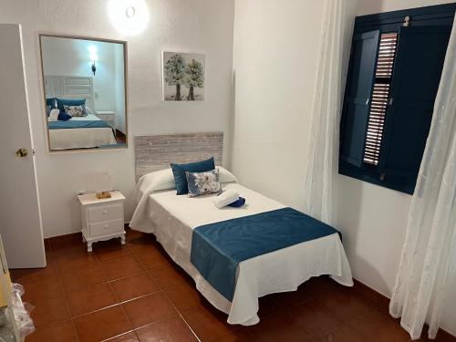 - une petite chambre avec un lit et un miroir dans l'établissement Casa Rural La Aldea, à San Clemente
