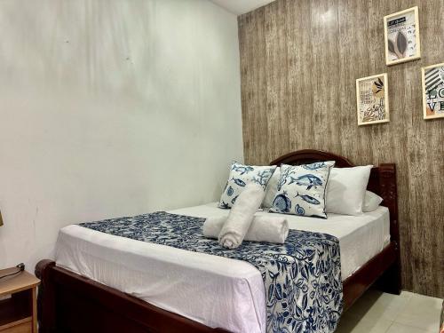 Schlafzimmer mit einem Bett mit blauen und weißen Kissen in der Unterkunft Hotel Casa Centro Historico De Cartagena Colombia in Cartagena de Indias