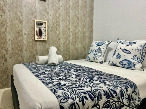 Schlafzimmer mit einem Bett mit blauer und weißer Bettwäsche und Kissen in der Unterkunft Hotel Casa Centro Historico De Cartagena Colombia in Cartagena de Indias