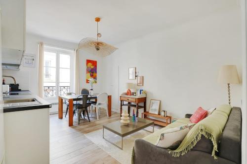 a living room with a couch and a table at OBERKAMPF - BASTILLE Charming apartment in Paris