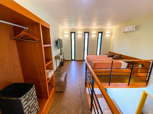 a bedroom with a bunk bed and a room with a couch at Villas Zamna - Jungle Villas in Cozumel