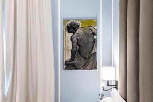 a picture of a statue in a room with a curtain at Glimpse Hotel in Florence