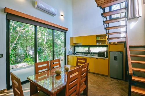 a kitchen with yellow cabinets and a wooden table at Villas Zamna - Jungle Villas in Cozumel