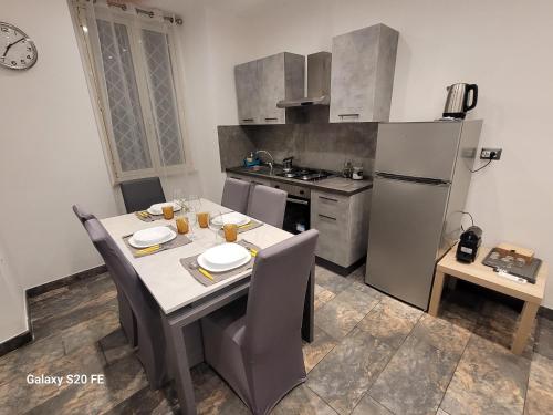 une cuisine avec une table avec des chaises et un réfrigérateur dans l'établissement Vatican house 98, à Rome