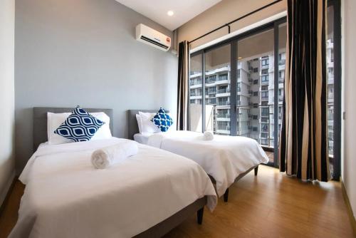 twee bedden in een kamer met een raam bij Comfy 3BR Apt in Danga Bay FREE Parking Sea View in Johor Bahru