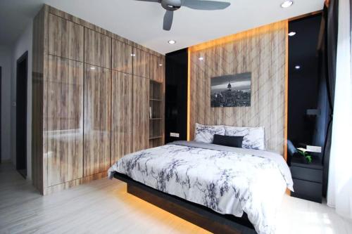 ein Schlafzimmer mit einem großen Bett und einer Holzwand in der Unterkunft A Stylish High-Floor 2BR Suasana Suites Views in Johor Bahru