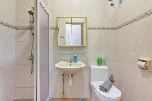 a bathroom with a sink and a toilet and a mirror at A Stylish & Spacious 4BR Home for Family Getaways in Kuala Lumpur