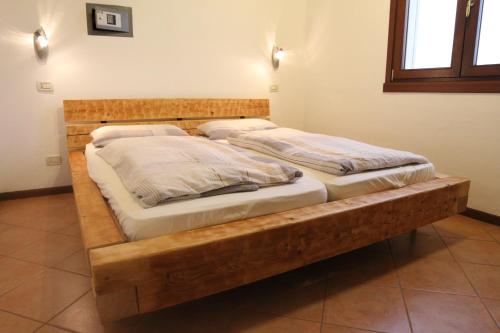 twee bedden in een kamer met een houten bedframe bij Lagosuite in Peschiera del Garda