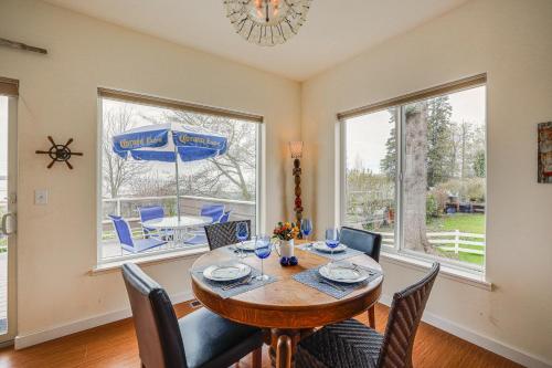a dining room with a table and chairs and windows at Beautiful Birch Bay Retreat with Deck and Fire Pit! in Blaine