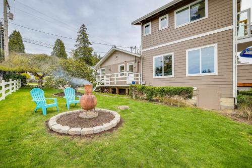 a yard with two chairs and a statue in front of a house at Beautiful Birch Bay Retreat with Deck and Fire Pit! in Blaine