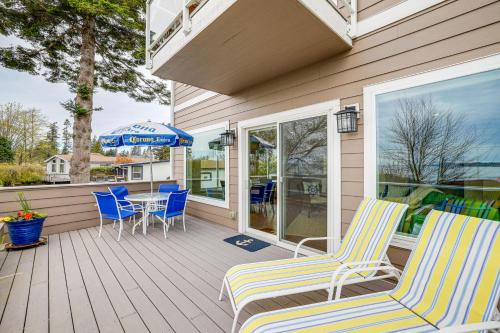a porch with chairs and a table and an umbrella at Beautiful Birch Bay Retreat with Deck and Fire Pit! in Blaine