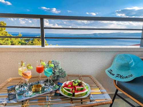 a tray of fruit and drinks on a table on a balcony at SunnySide luxury suites with free parking and swimming pool in Brela