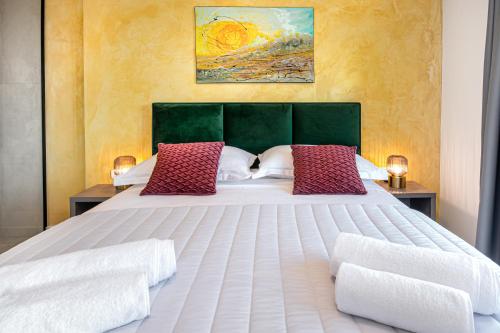 a bedroom with a large white bed with red pillows at SunnySide luxury suites with free parking and swimming pool in Brela