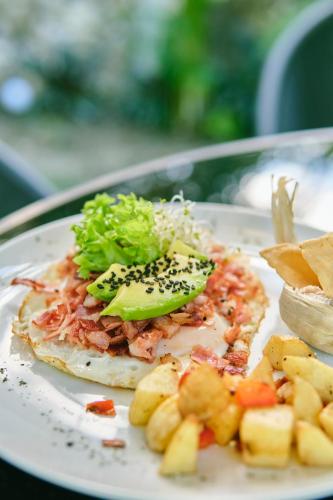 a white plate with a sandwich with broccoli and potatoes at Villas Zamna - Jungle Villas in Cozumel