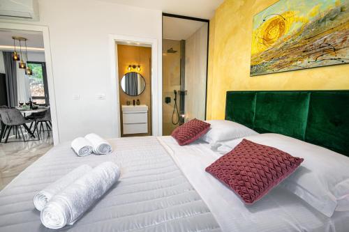 a large white bed with two pillows on it at SunnySide luxury suites with free parking and swimming pool in Brela