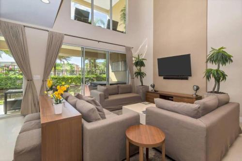 a living room with couches and a flat screen tv at Magical Disney Home (45366427) in Orlando