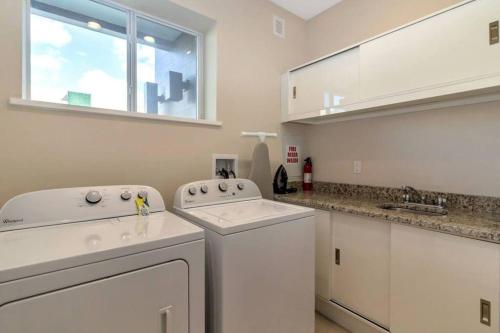 a white laundry room with a washer and dryer at Magical Disney Home (45366427) in Orlando