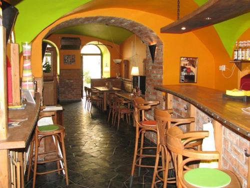 a restaurant with a bar with wooden stools at Penzion Pod Kašnou in Frýdek-Místek