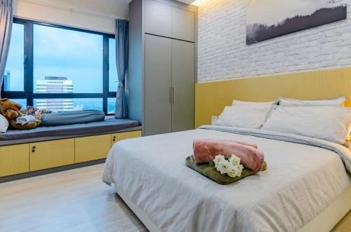 - une chambre avec un grand lit et une grande fenêtre dans l'établissement A Stylish & Cozy Suite at Suasana JB 03, à Johor Bahru