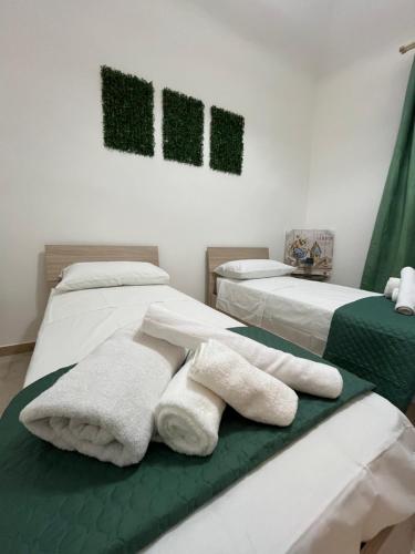 2 Betten in einem Zimmer mit Handtüchern darauf in der Unterkunft Ulivo in Trapani