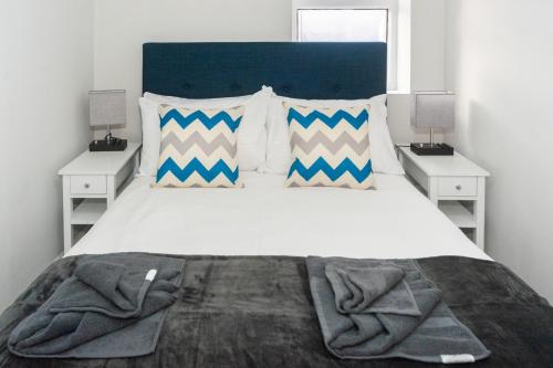 um quarto com uma grande cama branca com duas mesas de cabeceira em Modern 1BR Haven Central Croydon em Croydon