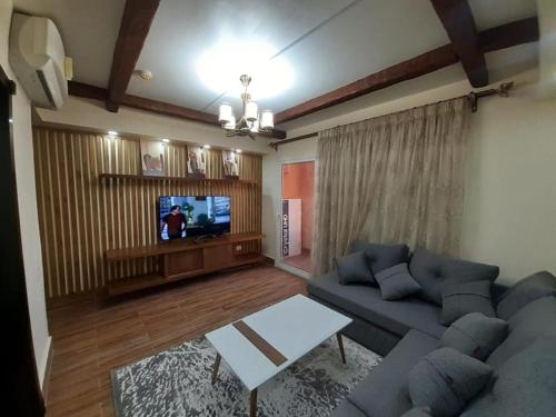 a living room with a couch and a tv at بورتو مارينا الساحل الشمالي in El Alamein