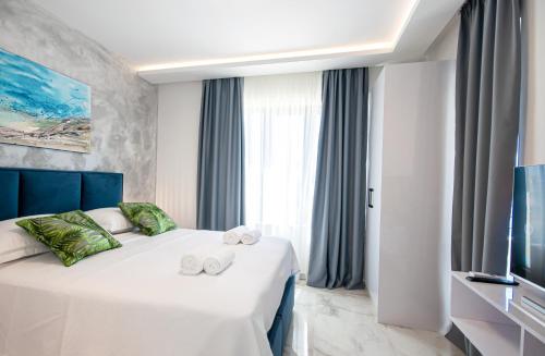 a hotel room with a bed with towels on it at SunnySide luxury suites with free parking and swimming pool in Brela