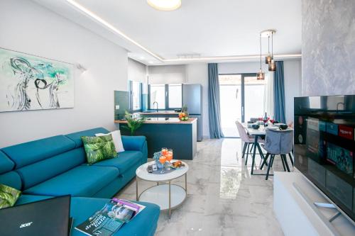 a living room with a blue couch and a table at SunnySide luxury suites with free parking and swimming pool in Brela