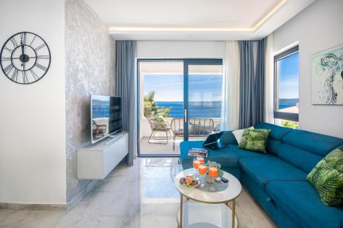 a living room with a blue couch and a tv at SunnySide luxury suites with free parking and swimming pool in Brela