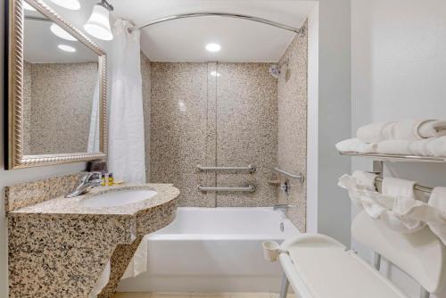 Baño blanco con bañera y lavamanos en Best Western Plus First Coast Inn and Suites en Yulee