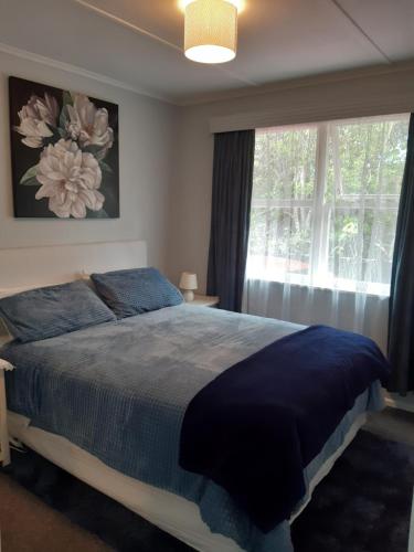 a bedroom with a large bed and a window at Happy Space in Waihi