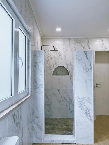 a bathroom with a glass shower with a mirror at Monte da Boavista in Alcácer do Sal