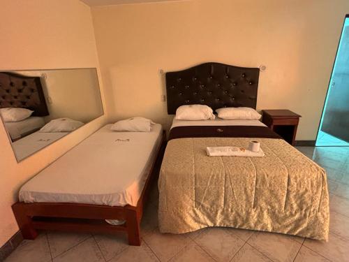 a bedroom with two beds and a mirror at Hospedaje San Blas in Lima