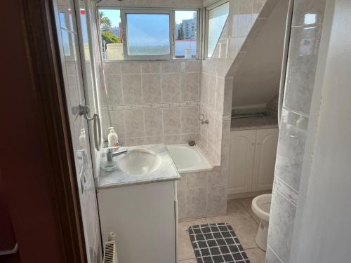a bathroom with a sink and a tub and a toilet at Hostal Casona del Mar in Viña del Mar