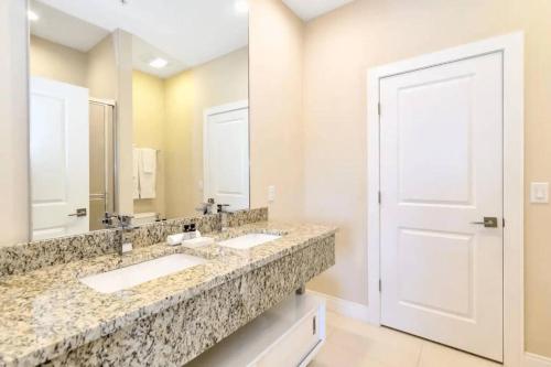 a bathroom with two sinks and a large mirror at Disney Dream Home (7662508) in Orlando