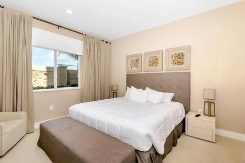 a bedroom with a large white bed and a window at Disney Dream Home (7662508) in Orlando