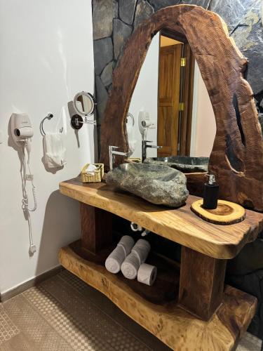 a bathroom with a wooden sink and a mirror at Hotel El Cielo en la Tierra in Quimbaya
