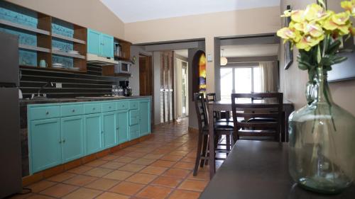 a kitchen with blue cabinets and a vase of flowers on a table at La Concha Beach Hotel & Club in La Paz