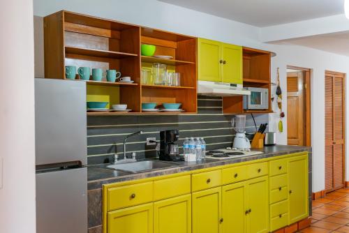 a kitchen with yellow cabinets and a sink at La Concha Beach Hotel & Club in La Paz