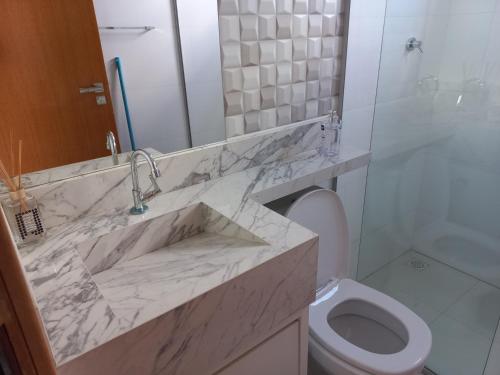 uma casa de banho com um lavatório em mármore e um WC. em apartamento studio setor Sul em Palmas