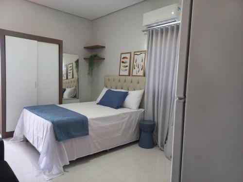 Schlafzimmer mit einem Bett mit blauer Bettwäsche und einem Fenster in der Unterkunft apartamento studio setor Sul in Palmas