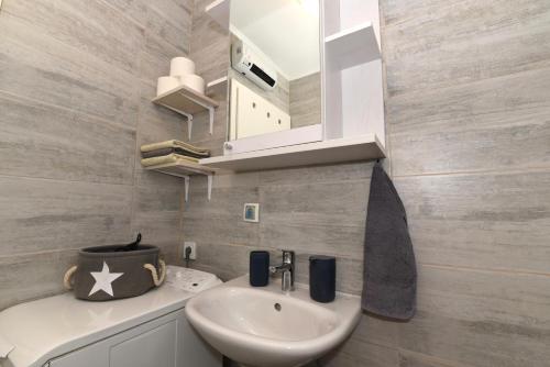 ein Bad mit einem Waschbecken und einem Spiegel in der Unterkunft Pločica in Ploče