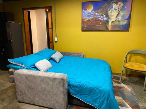 a bedroom with a bed and a painting on the wall at Container convertido en acogedor apartamento in Cajicá