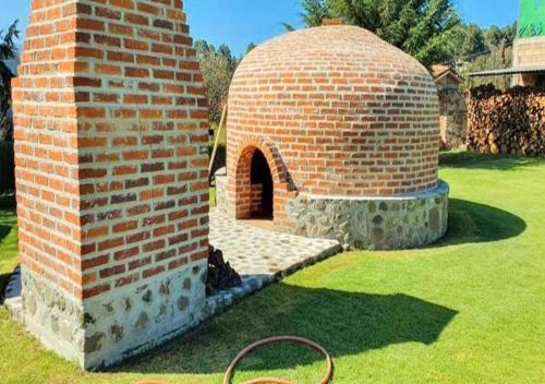 a brick oven in a yard with a grass field at Finca Marix, Villa del Carbón in Villa del Carbón