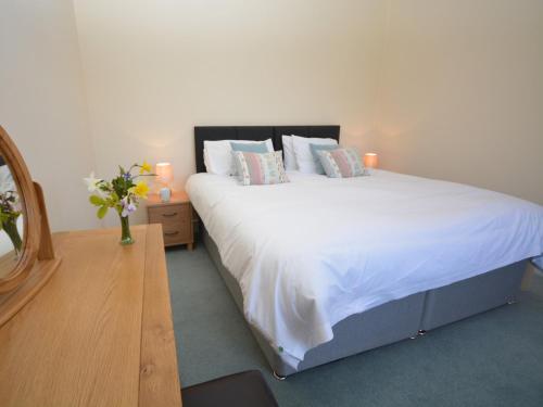 a bedroom with a large bed with white sheets and pillows at 5 bed in Barnstaple SHIRW in Shirwell