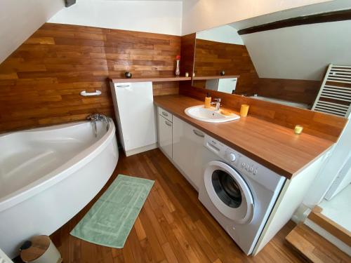 a bathroom with a washing machine and a sink at La Maison KDO in Châteauroux