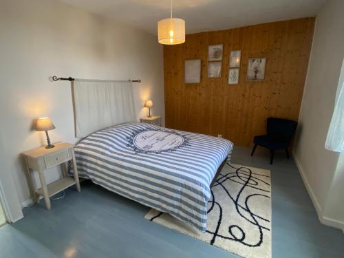 a bedroom with a bed and a table and a chair at La Maison KDO in Châteauroux