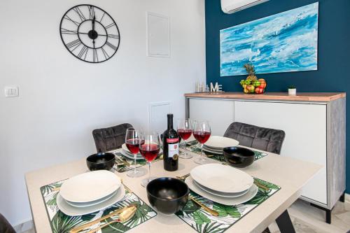 a table with plates and wine glasses on it at SunnySide luxury suites with free parking and swimming pool in Brela