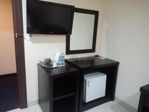 uma casa de banho com um toucador preto e um espelho. em Manise Hotel em Ambon
